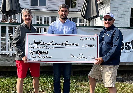 SymQuest President, Meg Fleming, presenting a $5,000 check to Austin Haynes of the Vermont Community Foundation; along with legacy employee, Jeff Culkin.